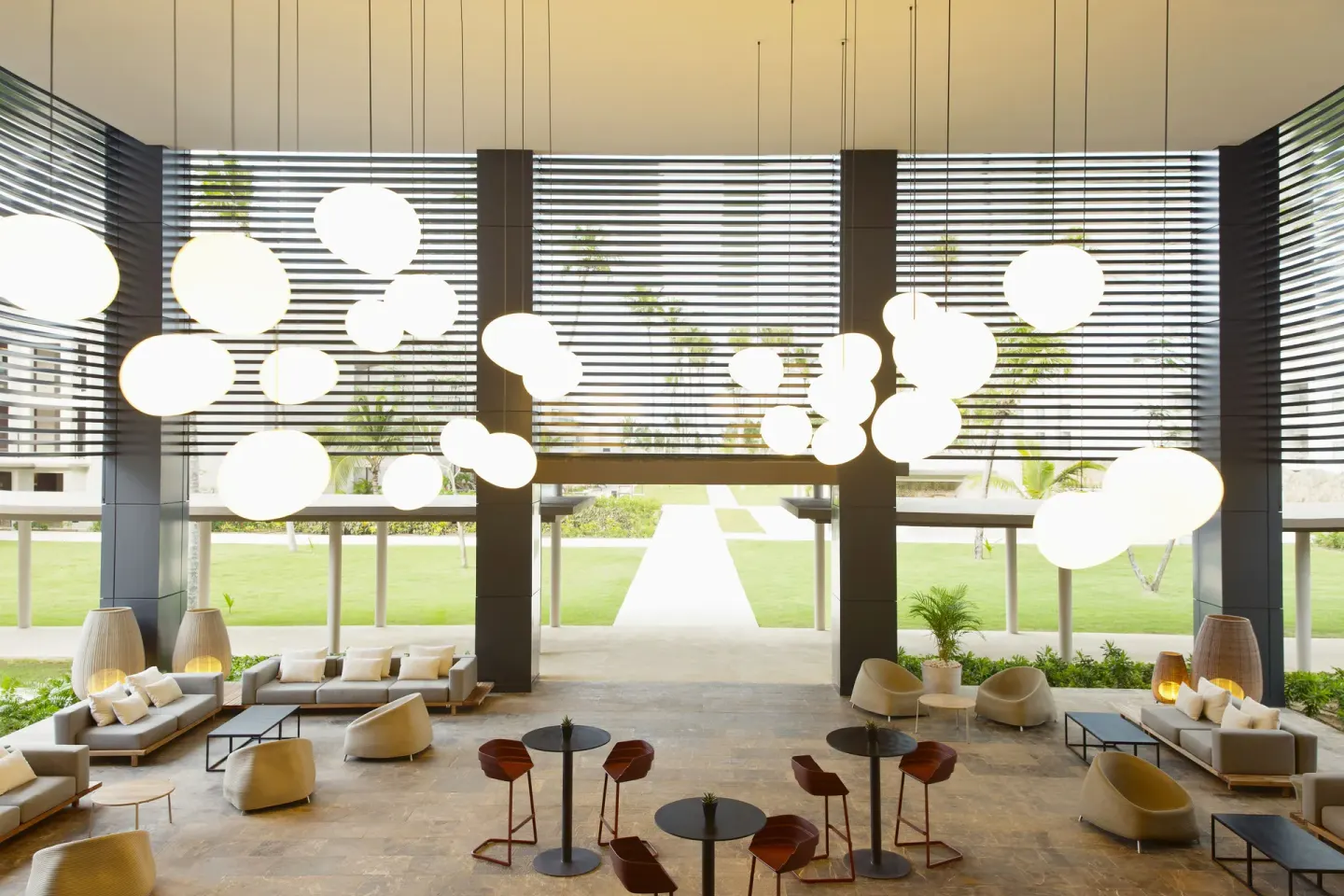 Open-air lobby lounge with pendant lights and garden views at Excellence El Carmen.