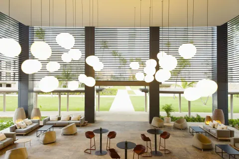 Open-air lobby lounge with pendant lights and garden views at Excellence El Carmen.