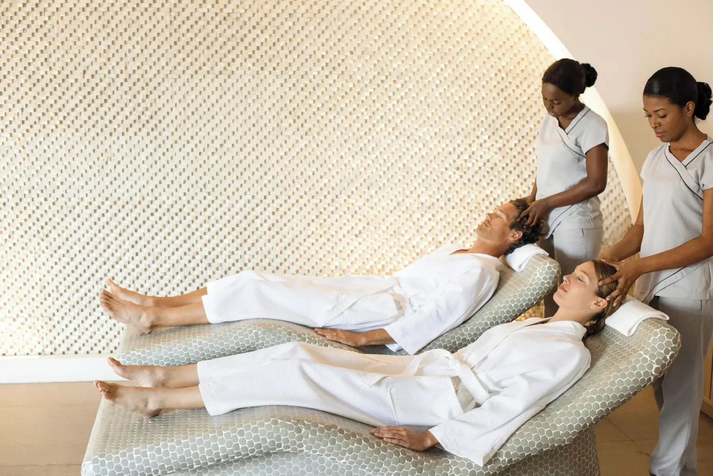 Couple in robes receiving scalp treatments on spa loungers at Excellence El Carmen.