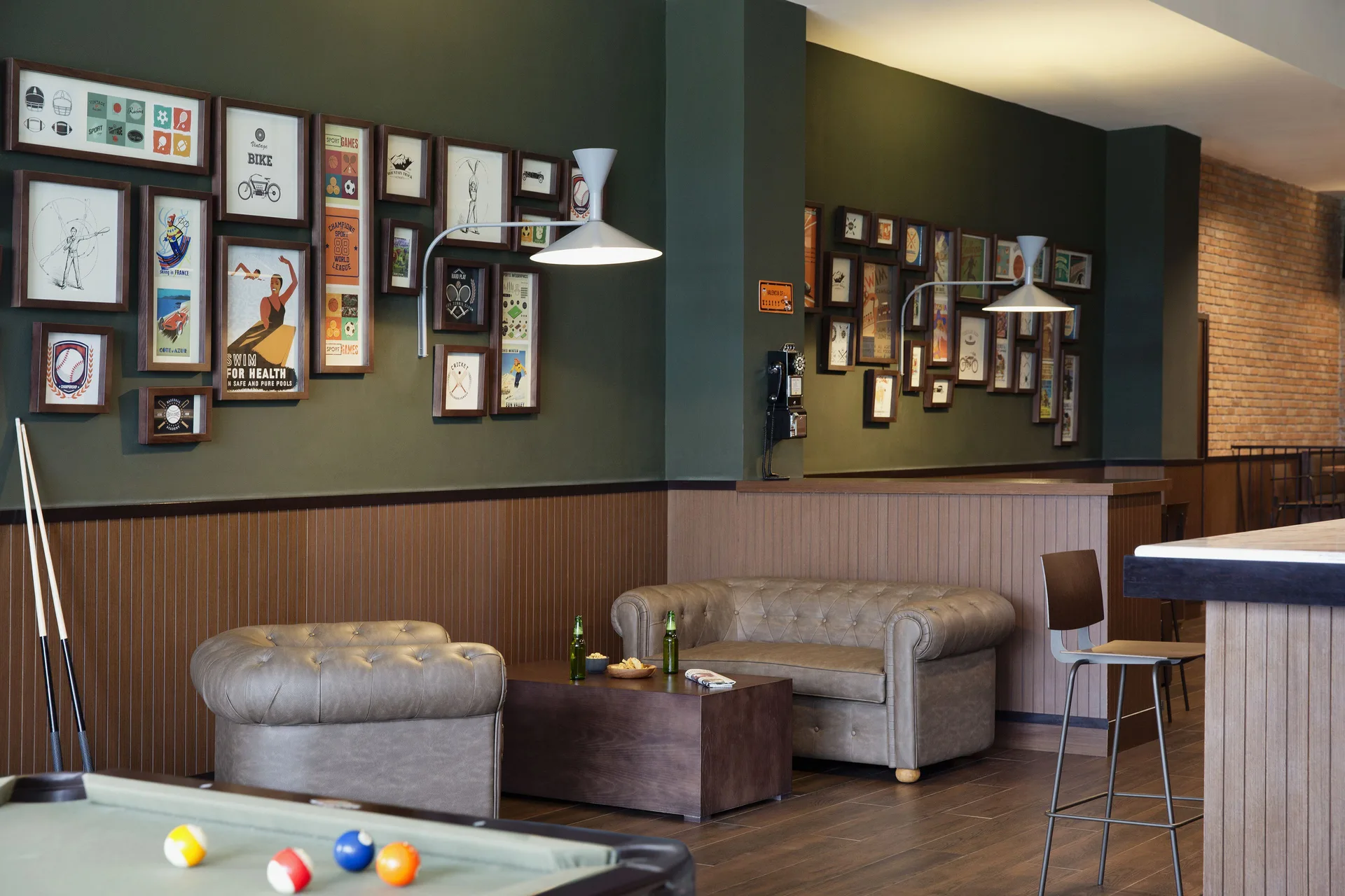 A sports bar lounge with pool table, sofas, and framed wall art at Excellence El Carmen.