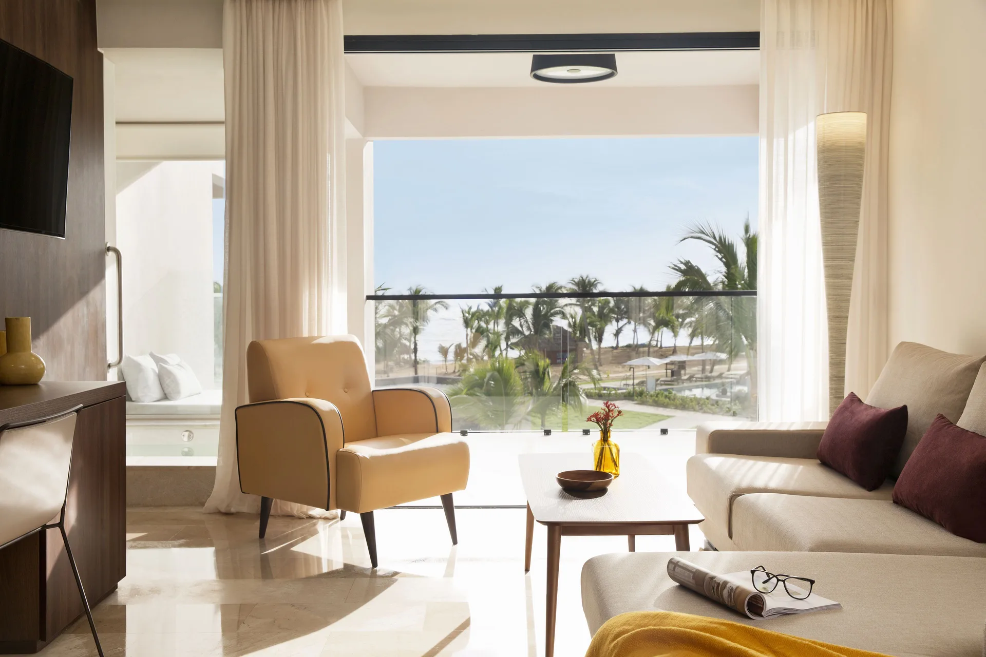 Junior Suite Ocean View living area with balcony and palm views at Excellence El Carmen.