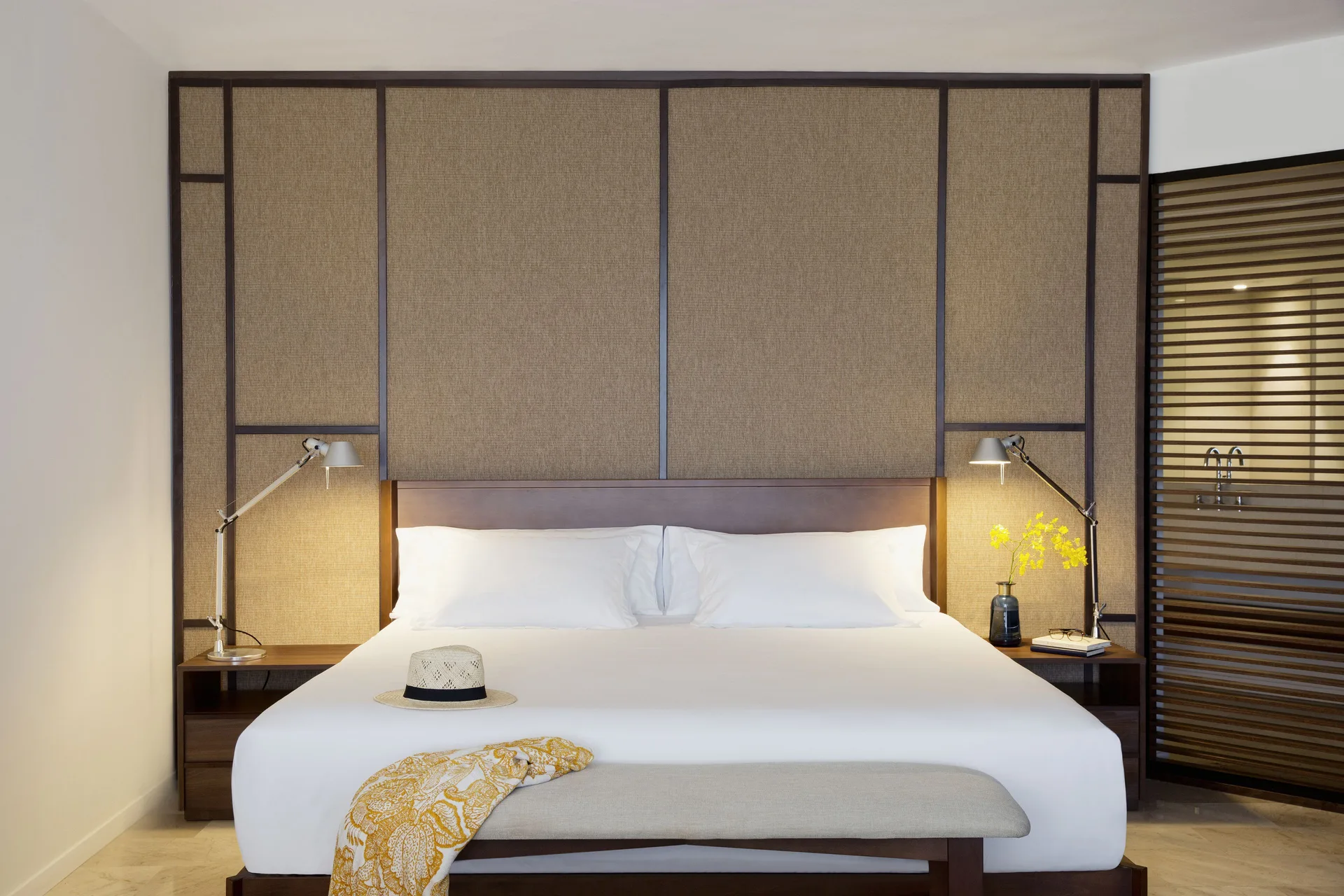Junior Suite Pool View king bed with bench and bedside lamps at Excellence El Carmen.