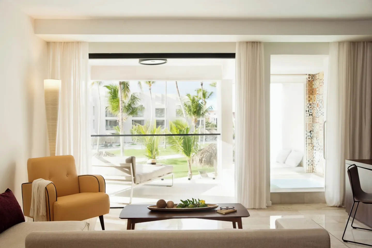 Junior Suite Pool View sitting area and balcony with palms at Excellence El Carmen.