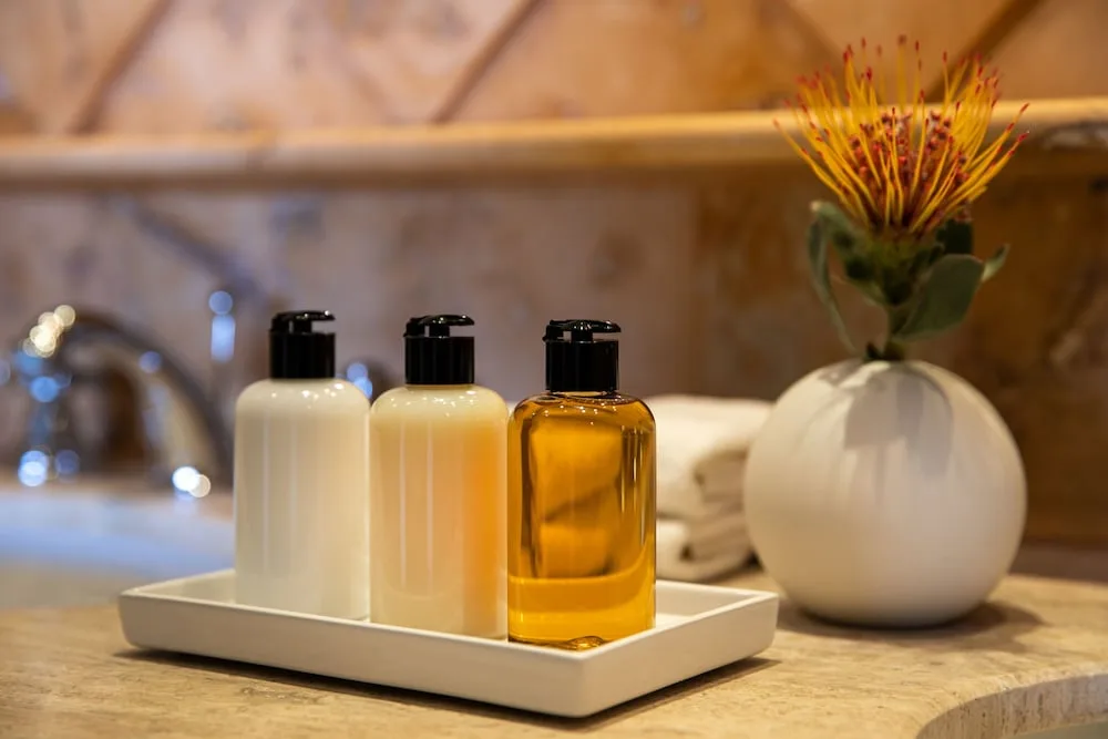 Bath amenity bottles and a flower on a bathroom counter at Excellence Playa Mujeres.