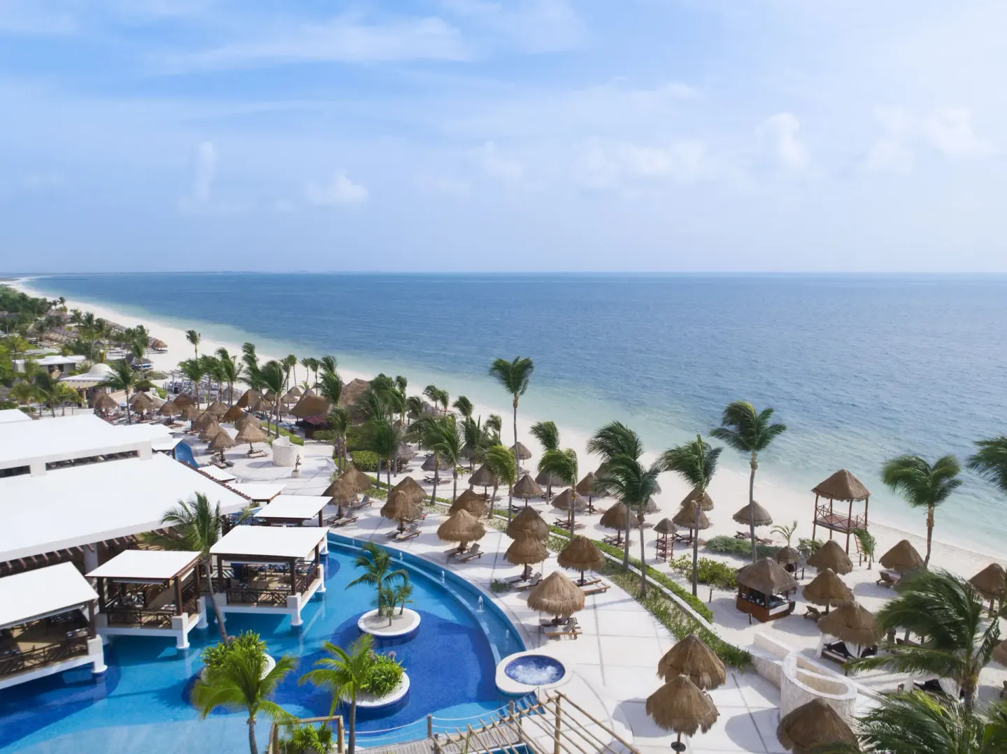 Aerial view of the beach, pool, and palapas at Excellence Playa Mujeres.