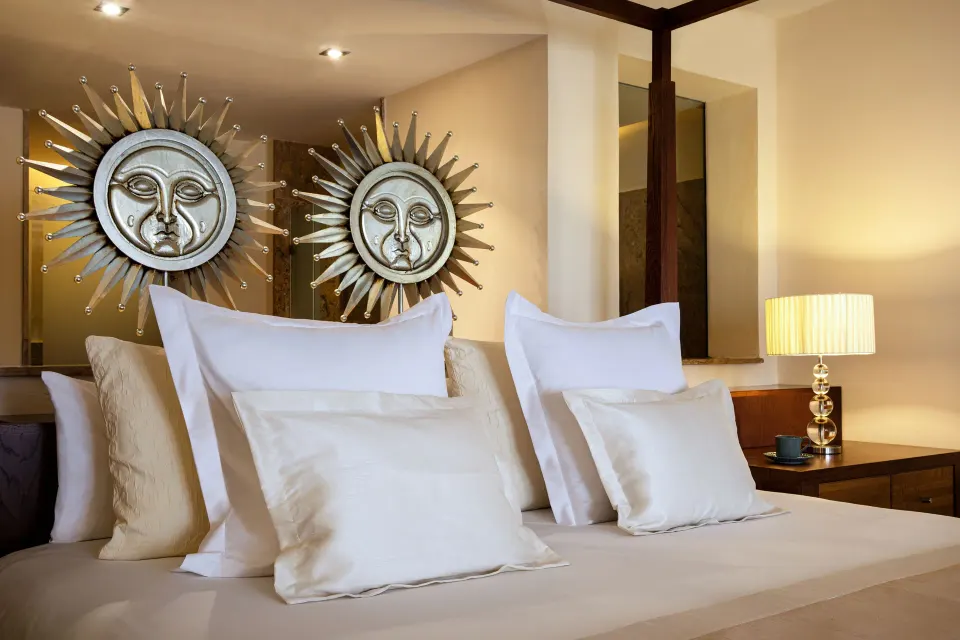 Junior Suite Spa or Pool View bed with sunburst wall art at Excellence Playa Mujeres.