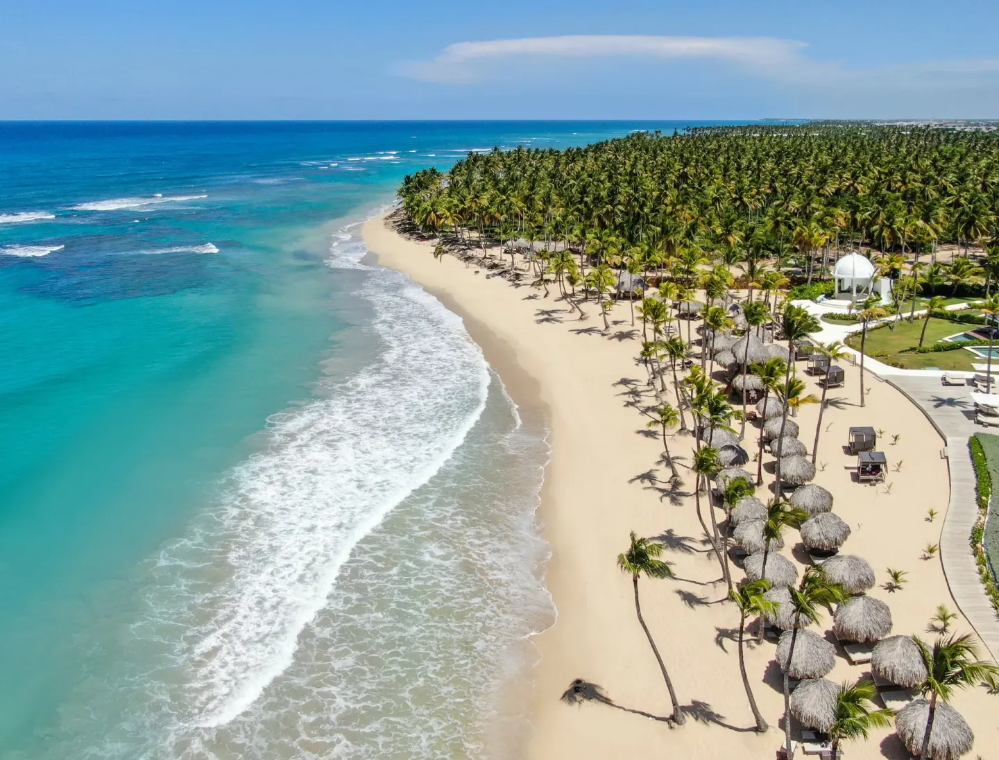 Aerial view of palm-lined beach and blue ocean at Excellence Punta Cana.