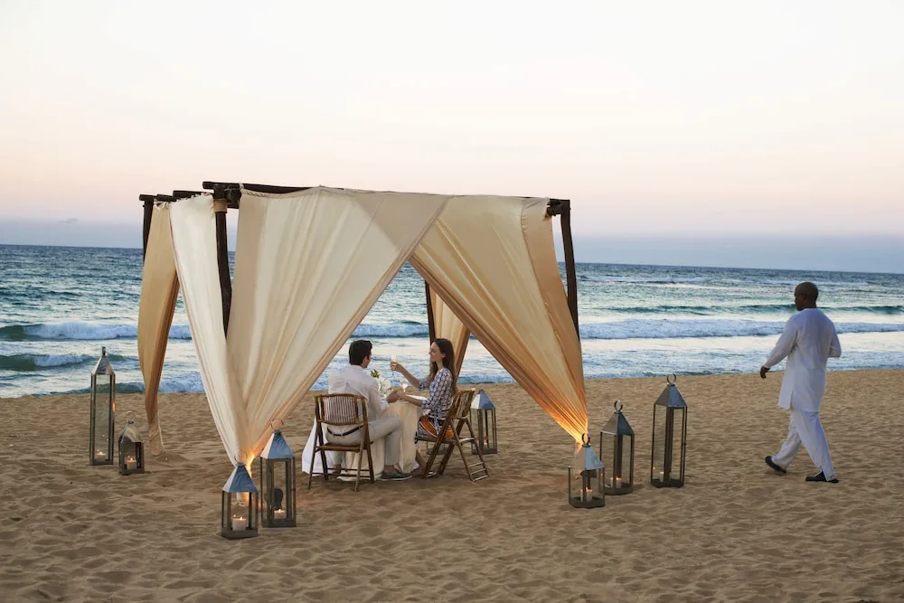 A couple dines under a draped beach canopy at Excellence Punta Cana.