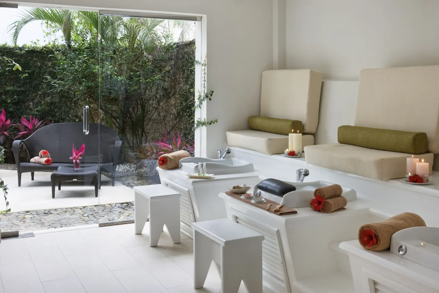 Spa pedicure room with cushioned chairs and garden patio at Excellence Punta Cana.