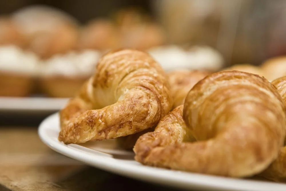 Fresh croissants are displayed on a white plate at Excellence Punta Cana.