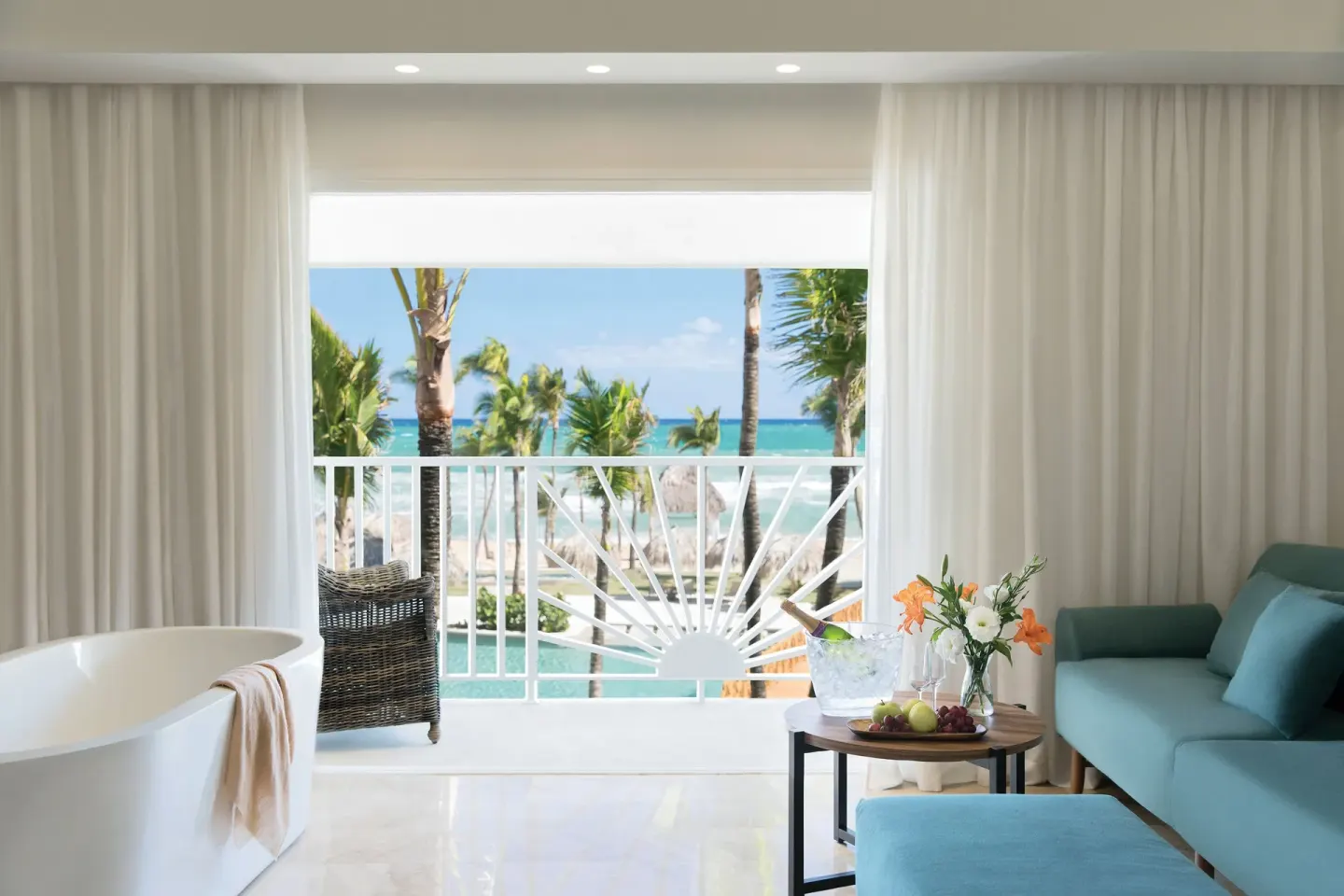 Junior Suite Ocean View sitting area and balcony at Excellence Punta Cana with palms and sea beyond.