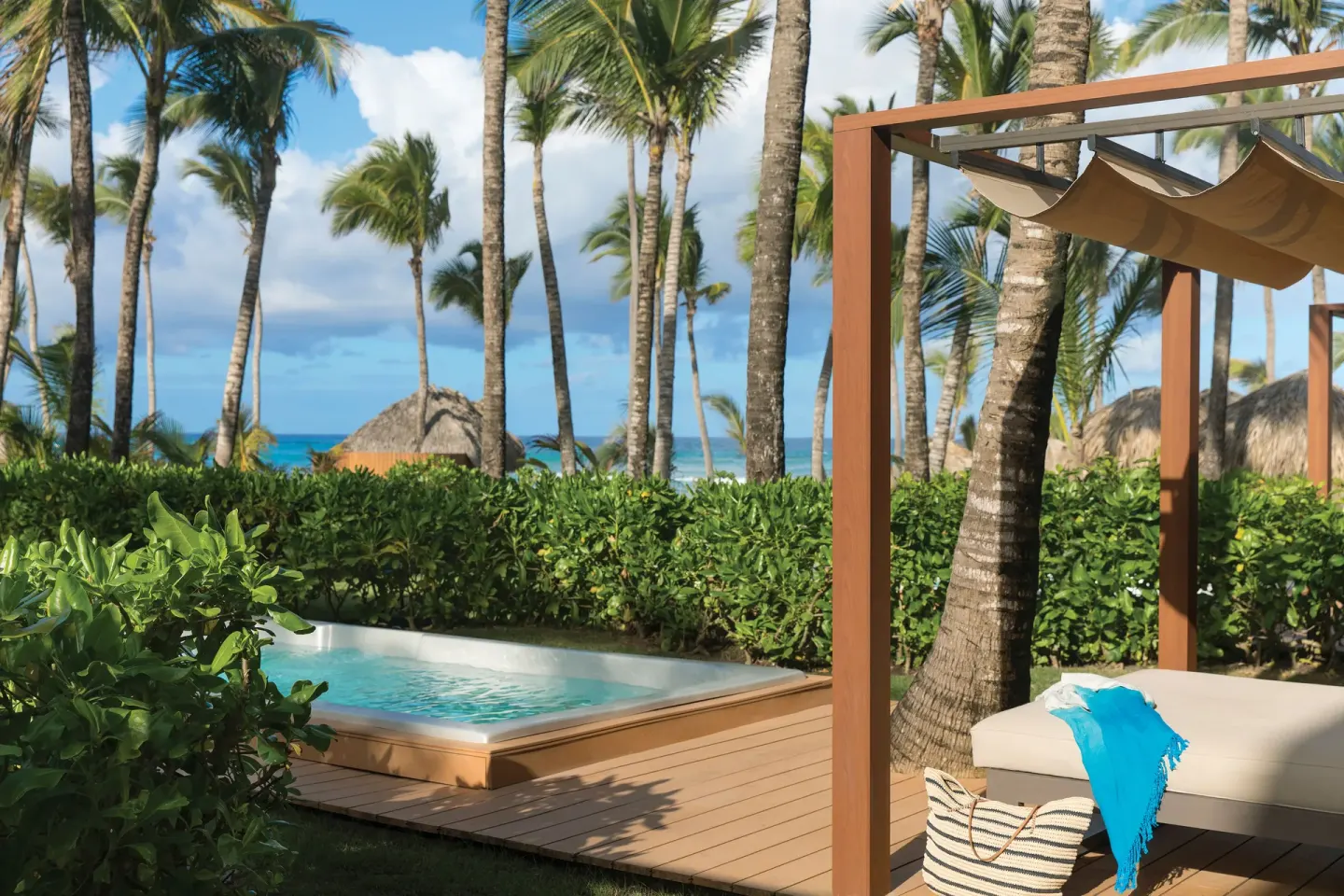 Private pool terrace of a Junior Suite with palms and ocean glimpses at Excellence Punta Cana.