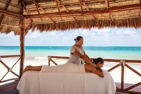 Beachside massage under a thatched palapa at Excellence Riviera Cancun.