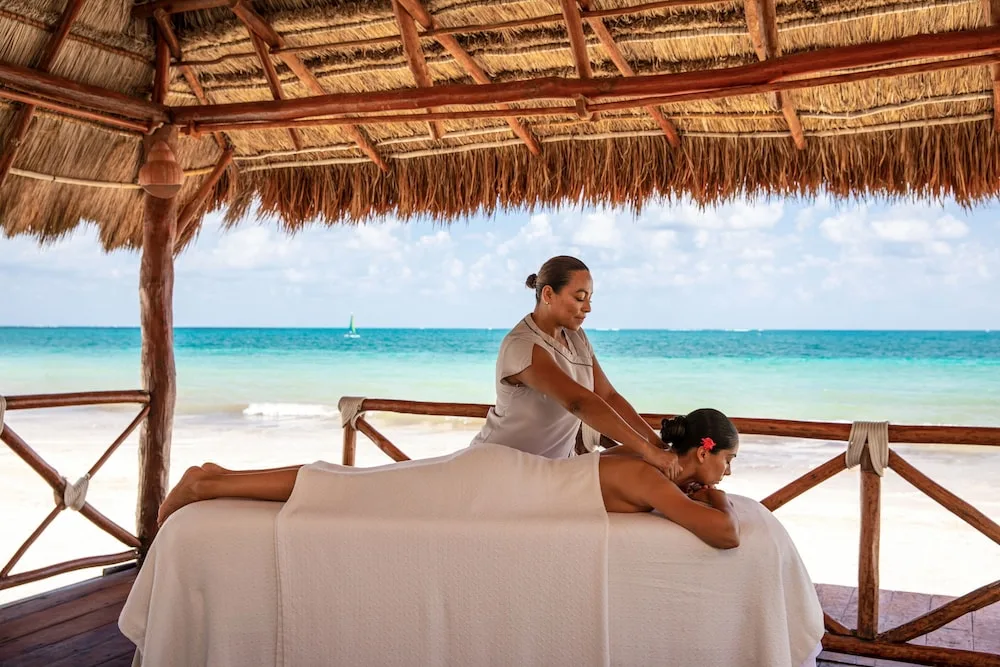 Beachside massage under a thatched palapa at Excellence Riviera Cancun.