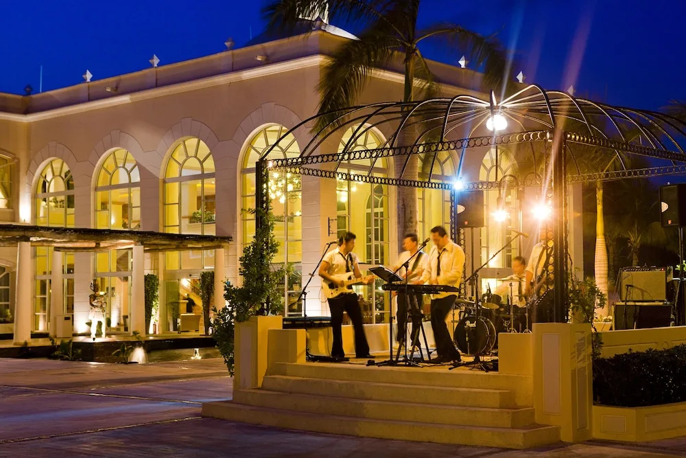 Outdoor evening band performance near arched windows at Excellence Riviera Cancun.