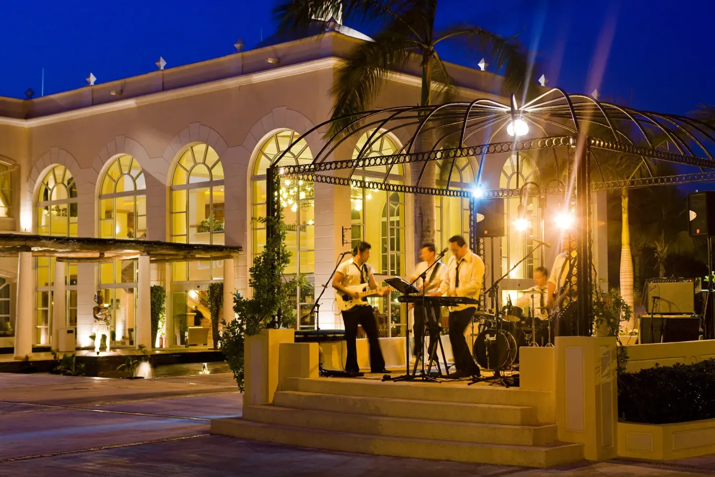 Live band performing on an outdoor stage at Excellence Riviera Cancun.