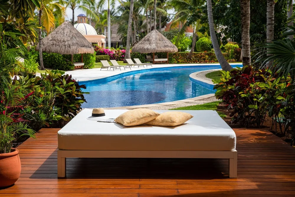 Poolside daybed on a wooden deck at Excellence Riviera Cancun.
