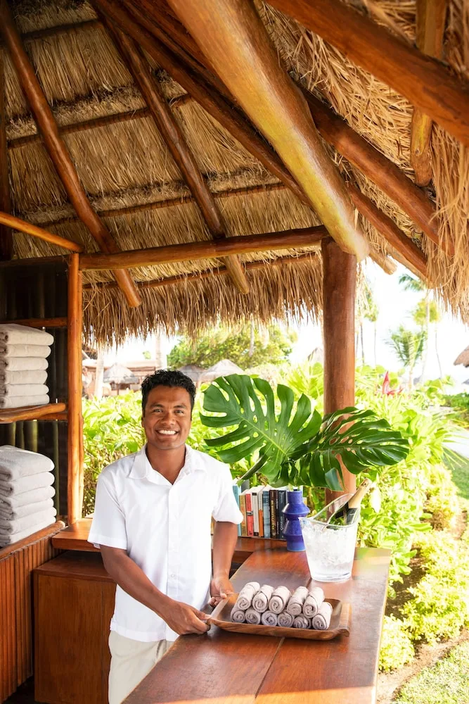 Towel station under a thatched hut with a staff member at Excellence Riviera Cancun.