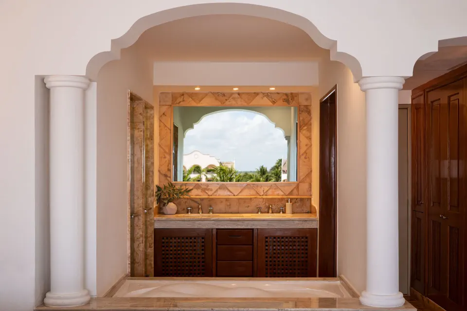 Junior Suite Spa or Pool View bathroom vanity with arched mirror at Excellence Riviera Cancun.