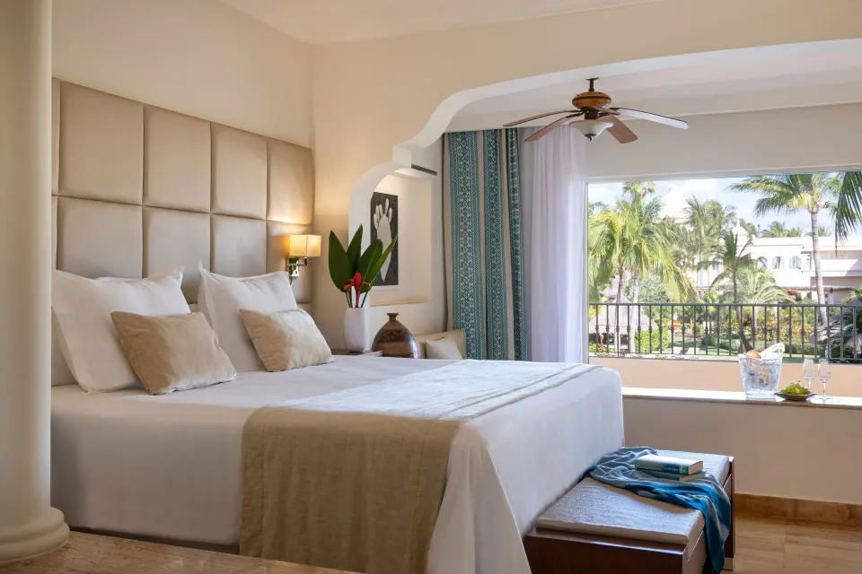 Junior Suite Spa or Pool View bedroom with king bed and balcony at Excellence Riviera Cancun.