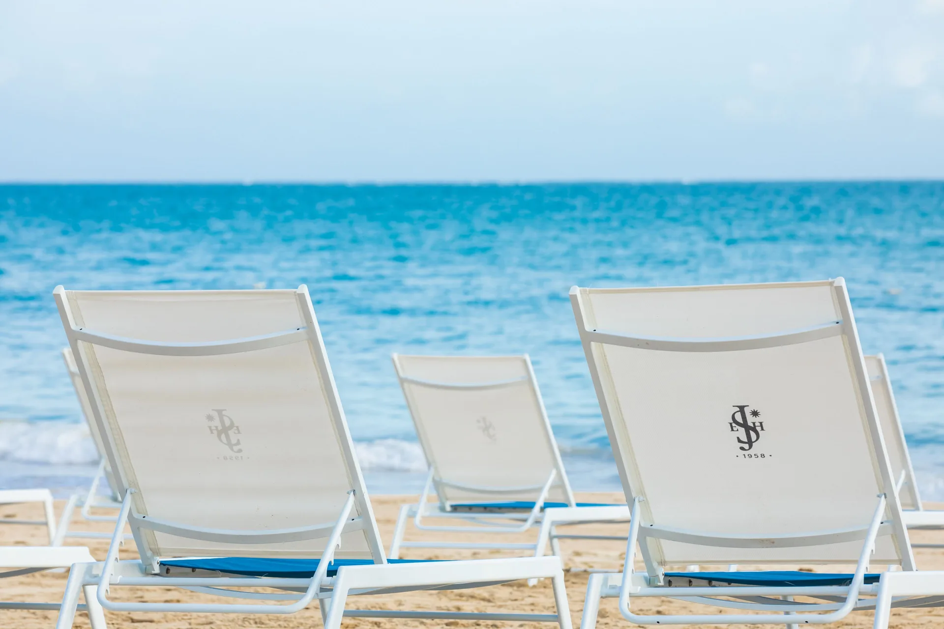 White beach loungers face the ocean at Fairmont El San Juan.