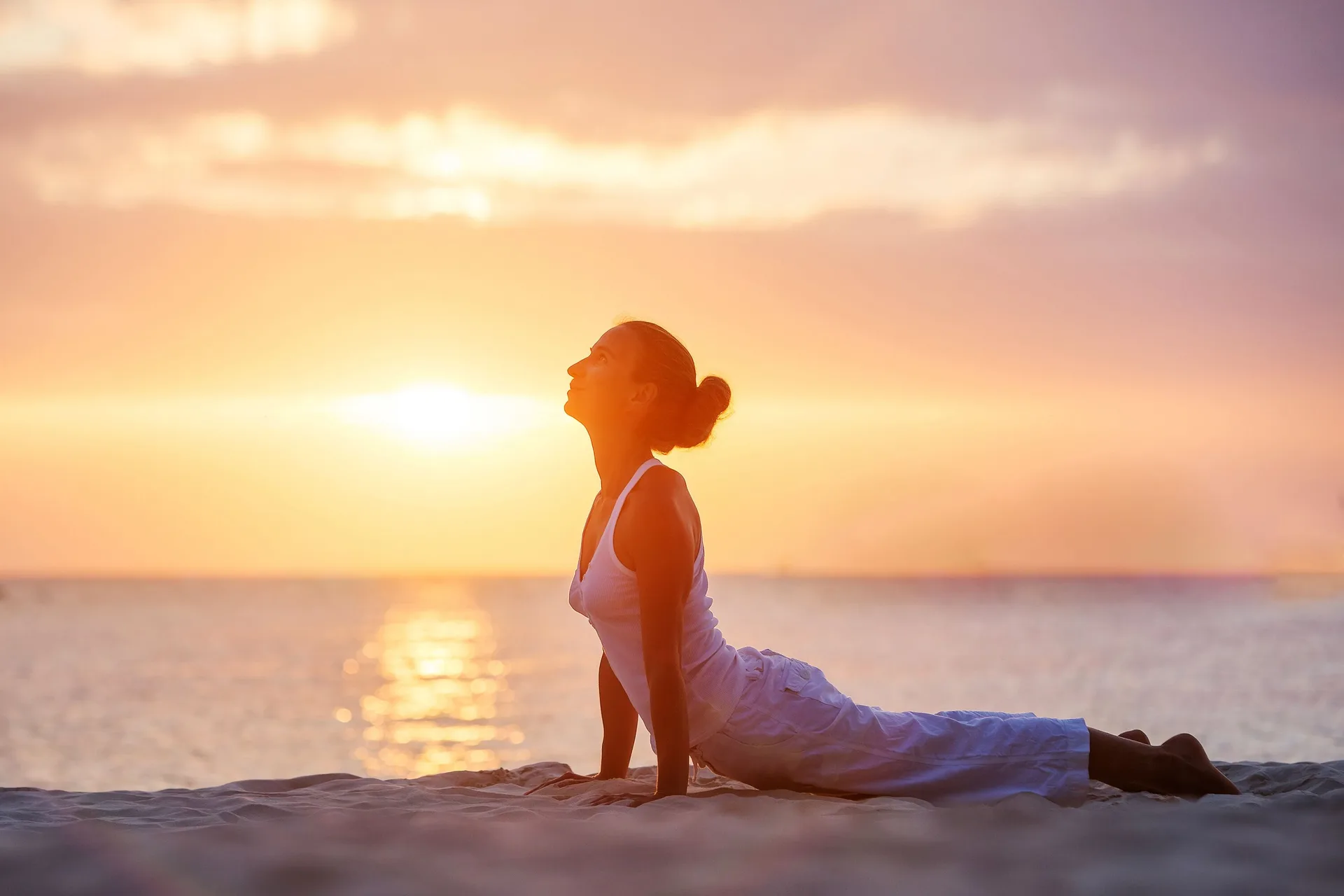 A guest practices yoga on the beach at sunset at Fairmont El San Juan.