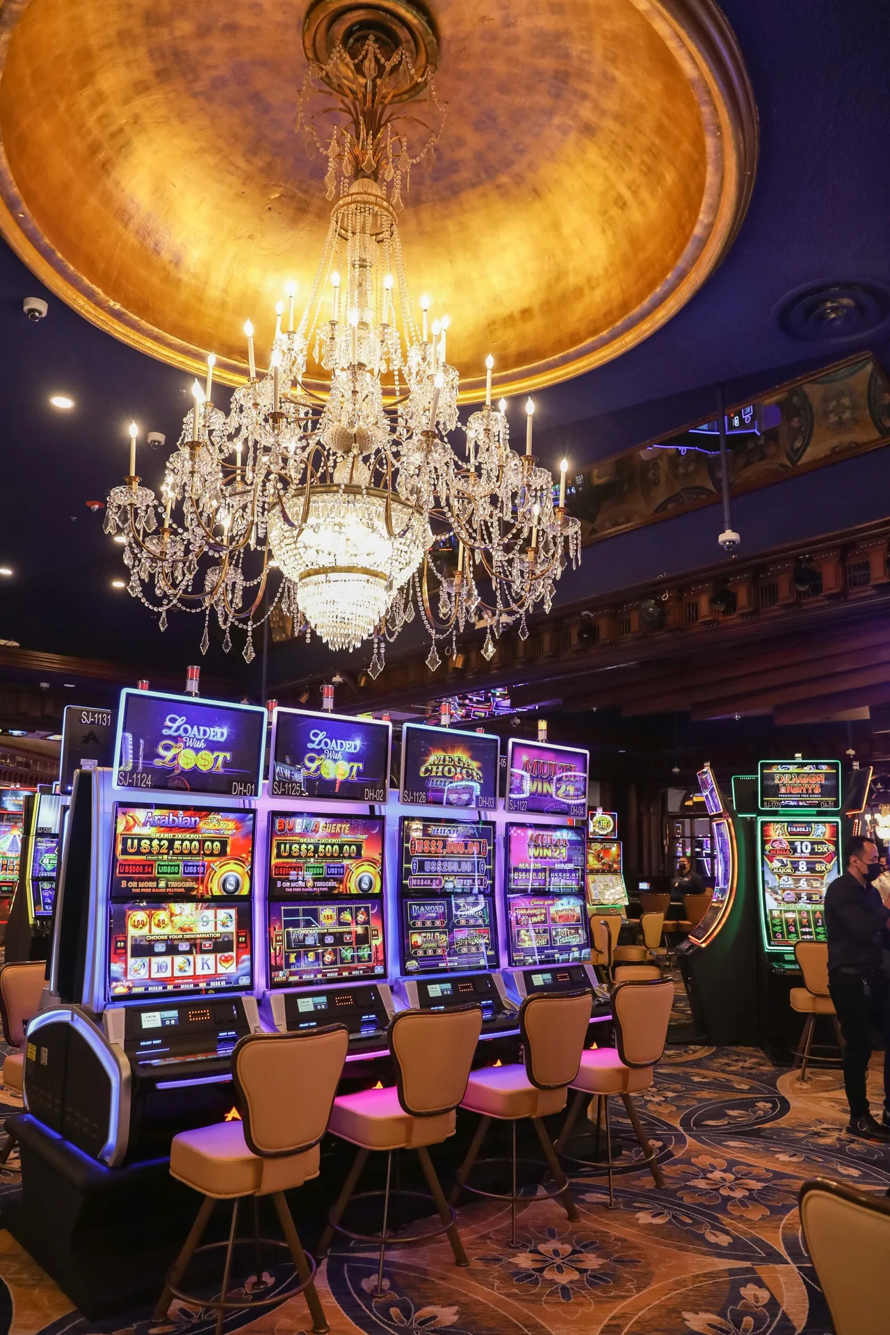 Slot machines and a crystal chandelier inside the casino at Fairmont El San Juan.