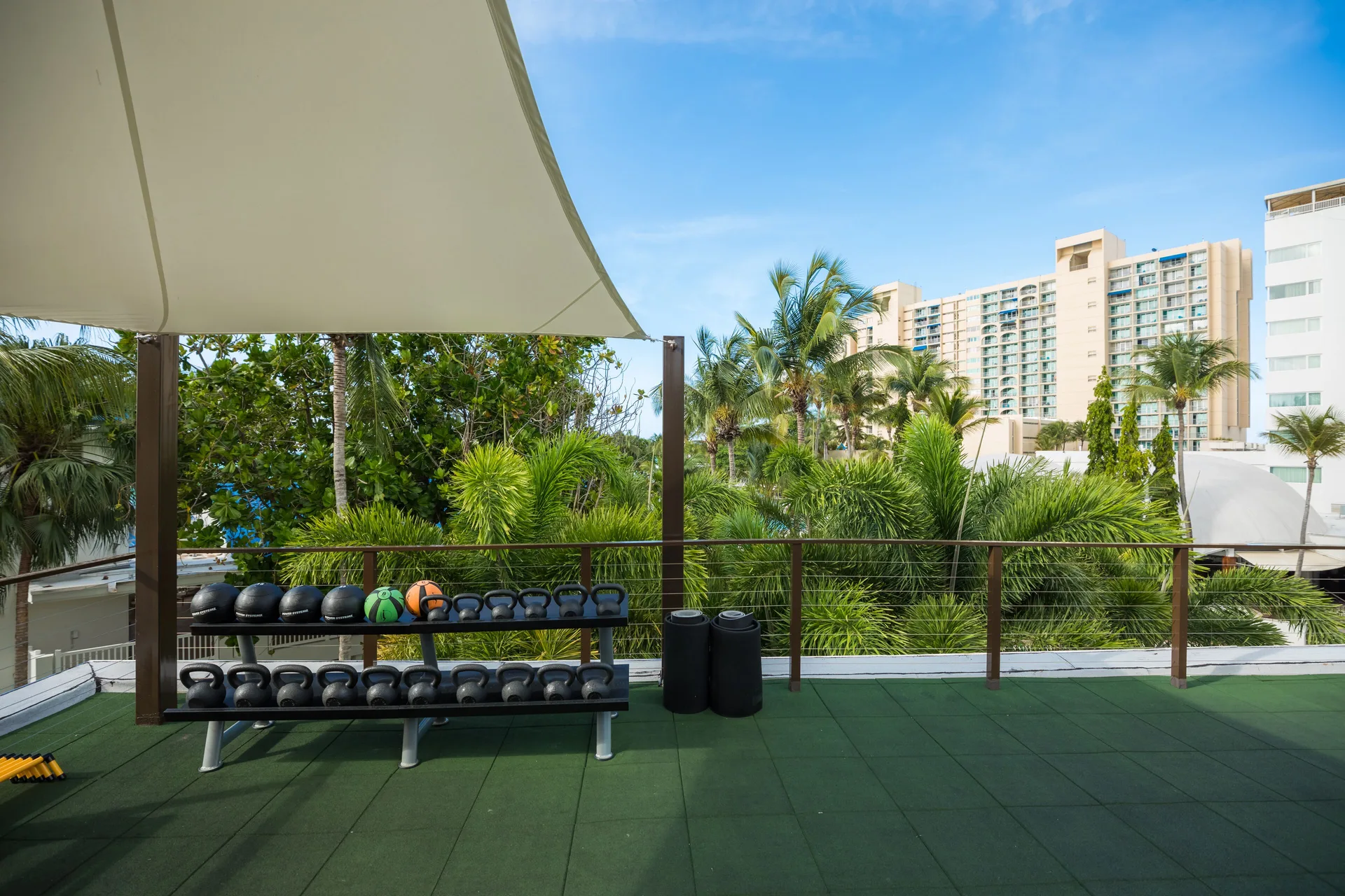 Outdoor fitness deck with kettlebells and resort tower views at Fairmont El San Juan.