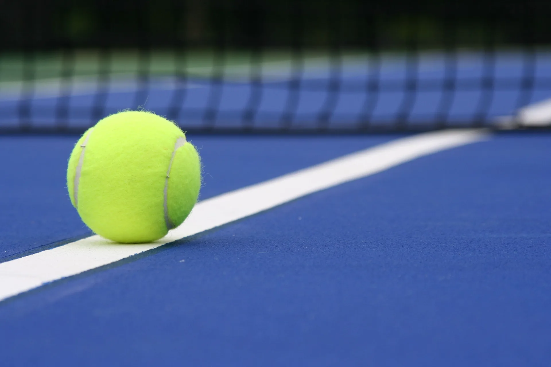 A tennis ball rests on a blue court line at Fairmont El San Juan.