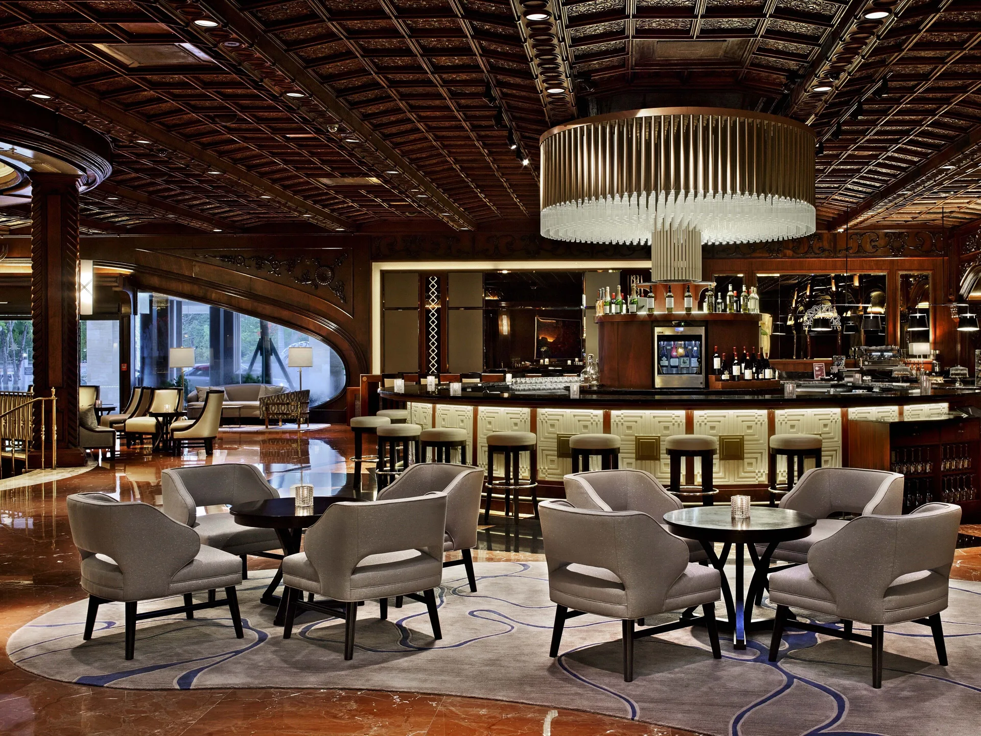 Lounge seating and a circular bar beneath a large chandelier at Fairmont El San Juan.