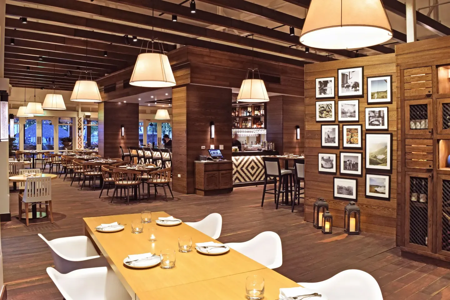 Restaurant interior with set tables, pendant lights, and wood walls at Fairmont El San Juan.
