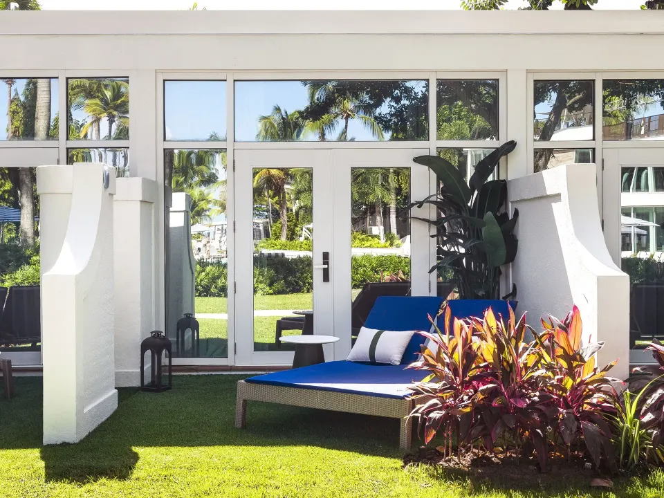 Bungalow Terrace exterior with blue lounge chair and glass doors at Fairmont El San Juan.