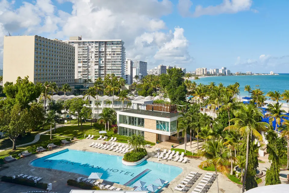 Aerial view of the pool, palms and beachfront setting at Fairmont El San Juan.