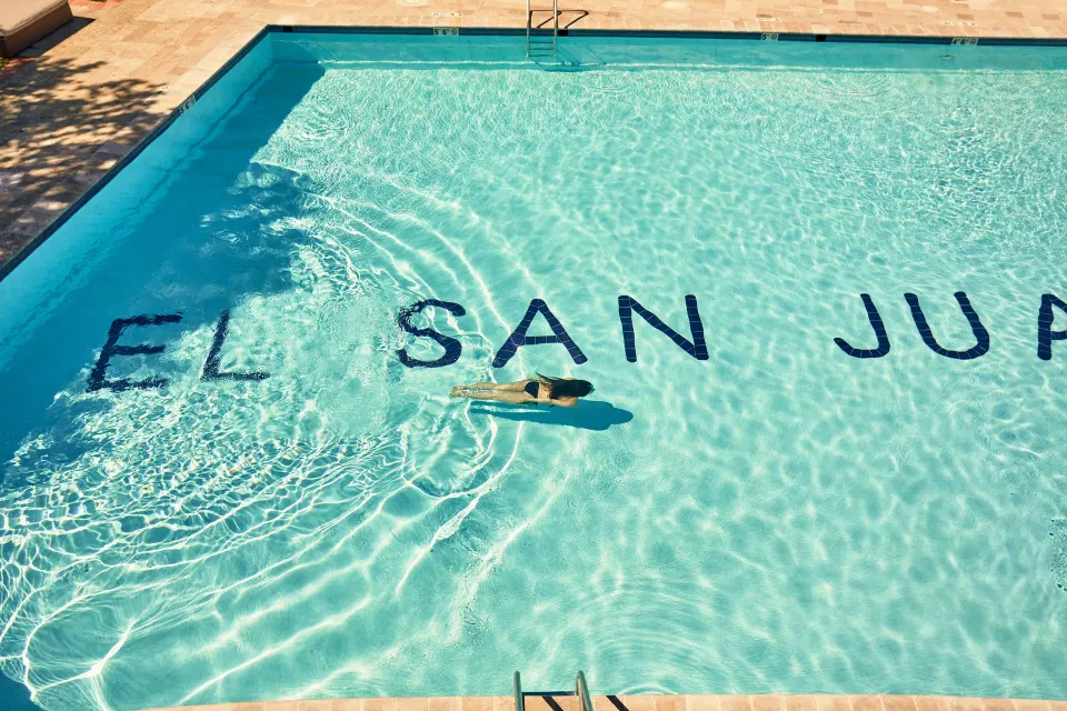 Swimmer in the pool with El San Juan Hotel lettering at Fairmont El San Juan.