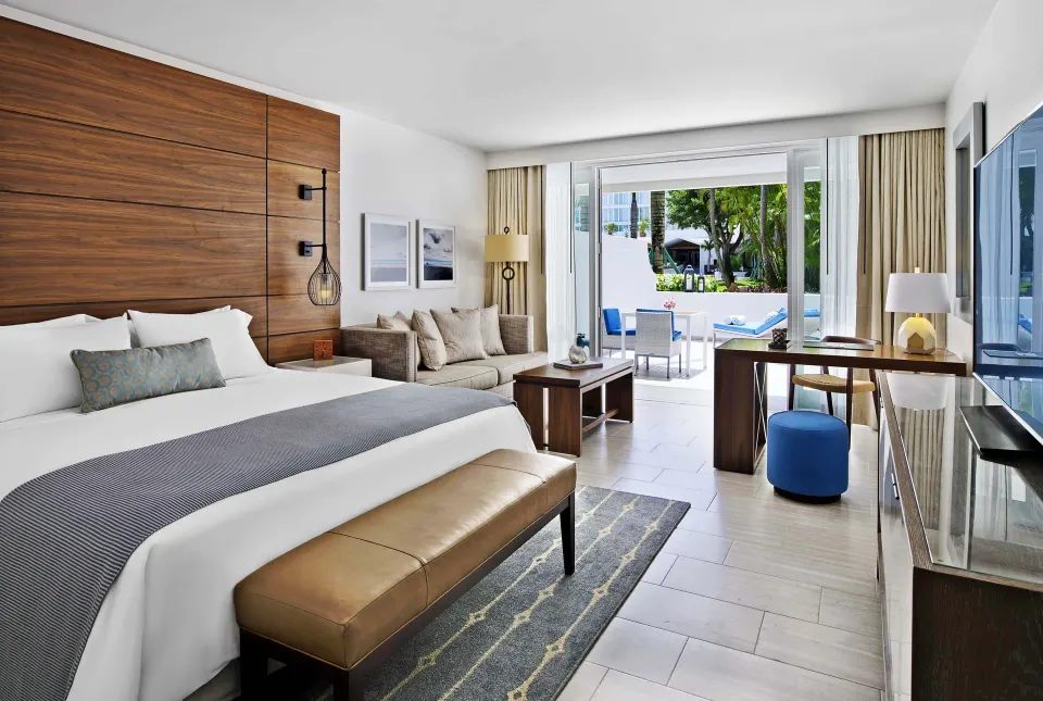 Villa room with king bed, sofa and poolside balcony at Fairmont El San Juan.