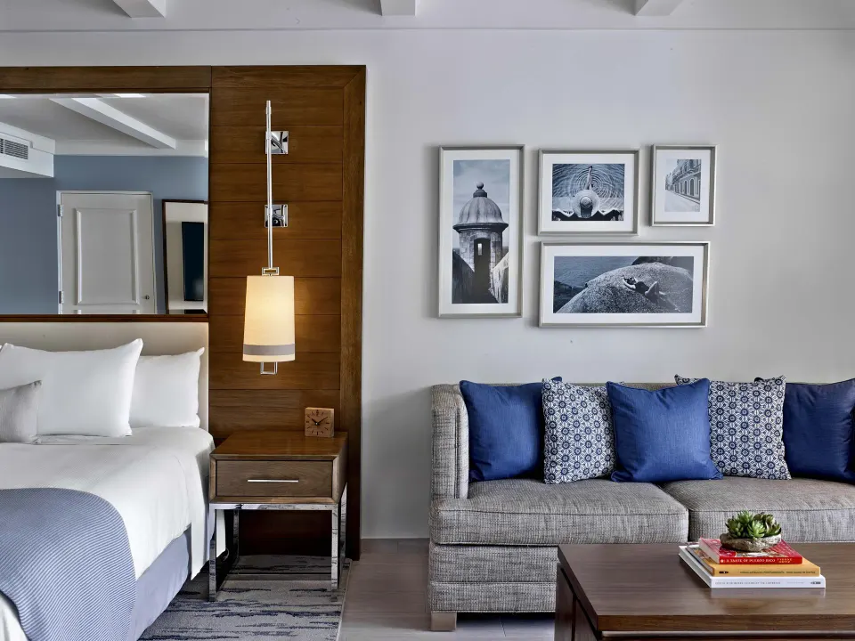 King bed and sofa seating area in a villa room at Fairmont El San Juan.