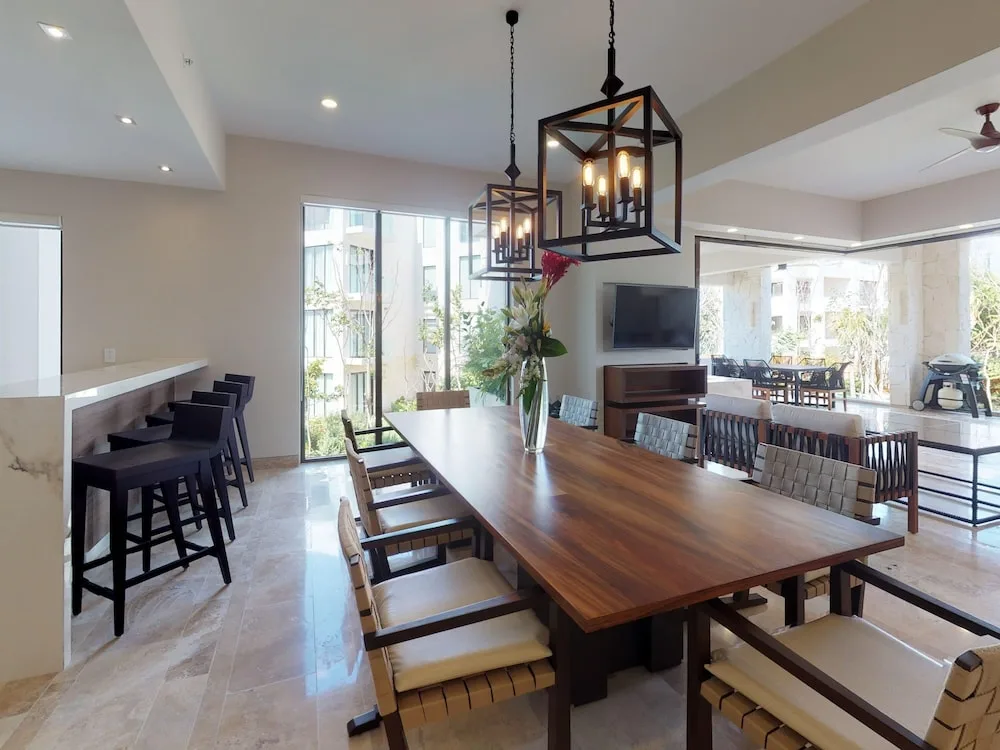 Dining area with long wood table and breakfast bar at Fairmont Heritage Place Mayakoba.