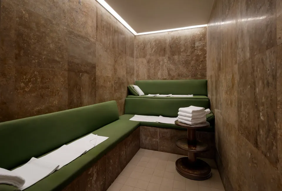 Steam or sauna room with green benches and folded towels at Fairmont Heritage Place Mayakoba.