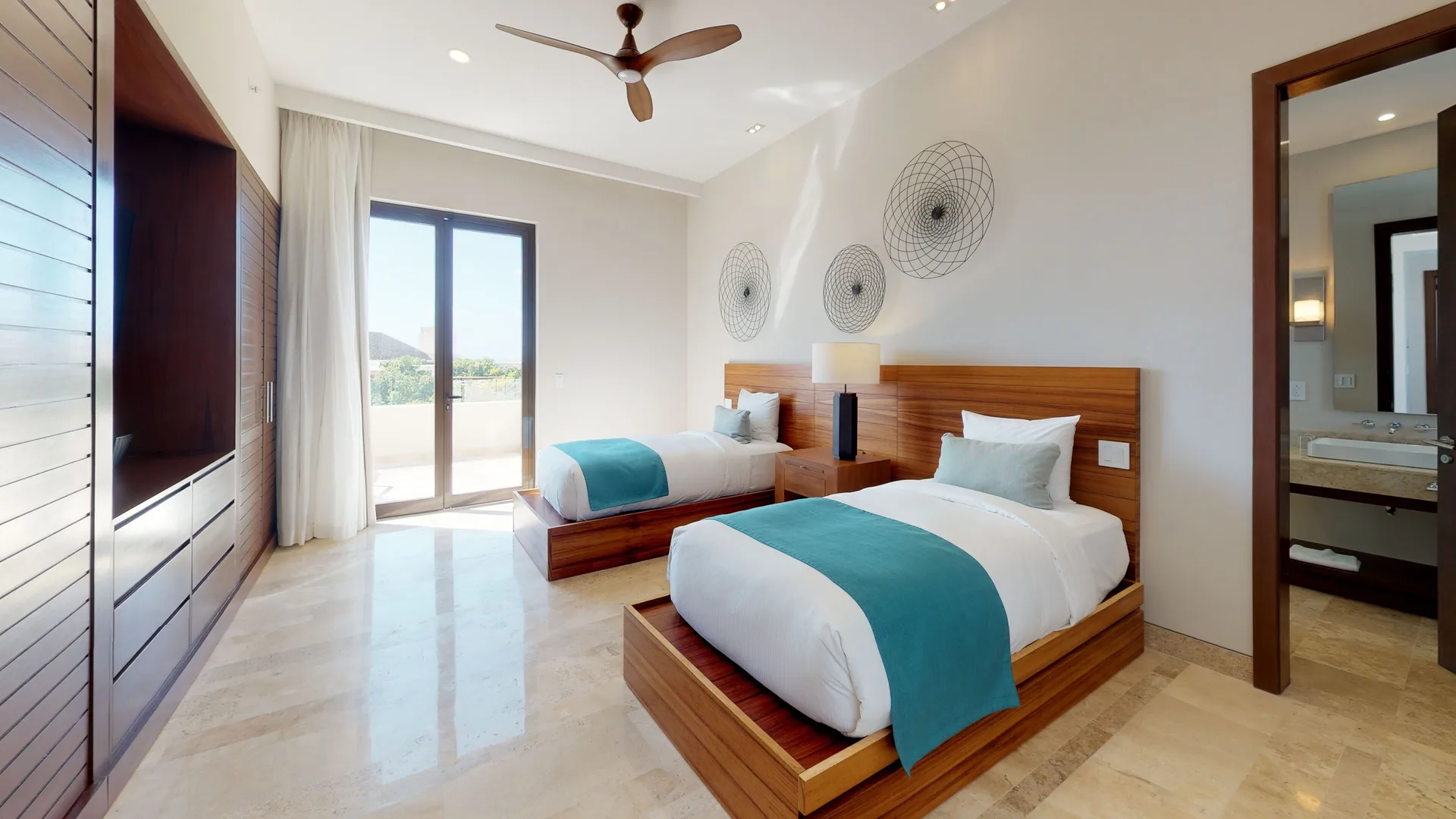 Twin-bed guest room with balcony doors and visible bathroom at Fairmont Heritage Place Mayakoba.