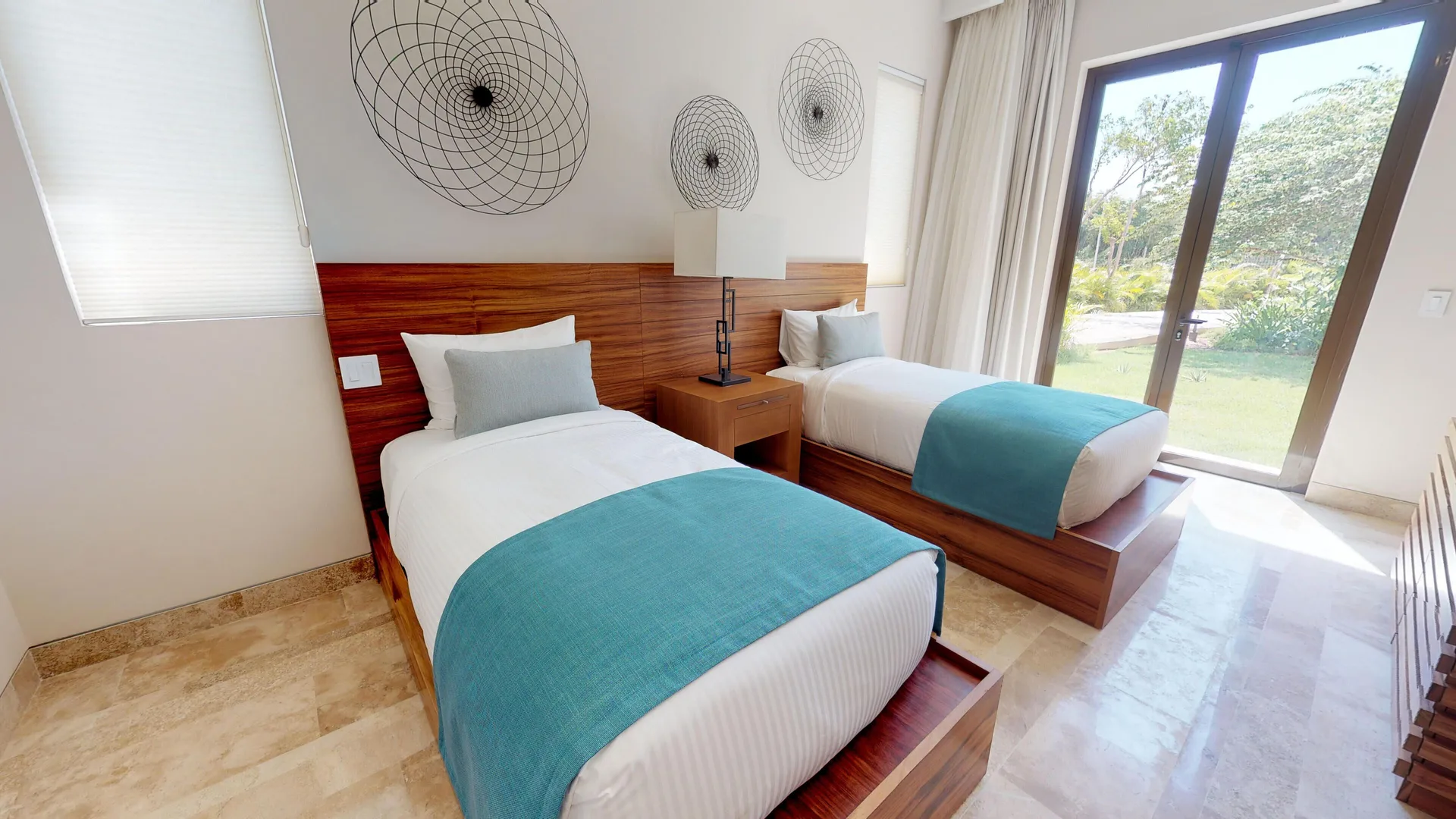 Twin-bed guest room with garden-facing glass doors at Fairmont Heritage Place Mayakoba.