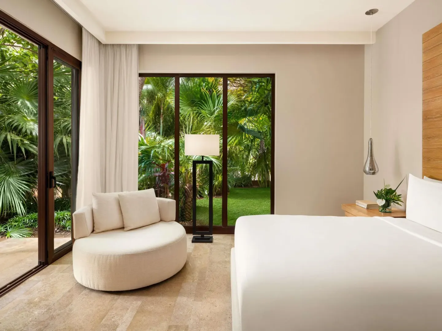King bedroom corner with lounge chair and garden windows at Fairmont Heritage Place Mayakoba.