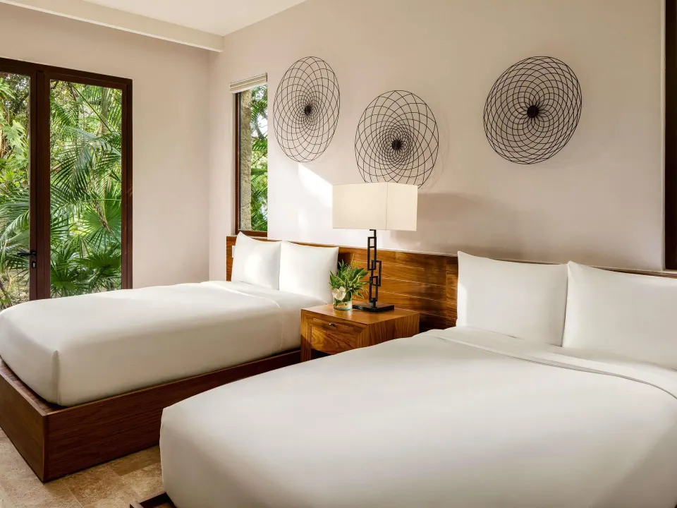 Two-bed garden villa bedroom with wood headboards at Fairmont Heritage Place Mayakoba.