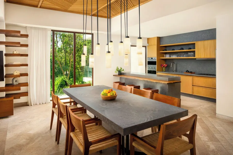 Villa dining table and open kitchen with pendant lights at Fairmont Heritage Place Mayakoba.