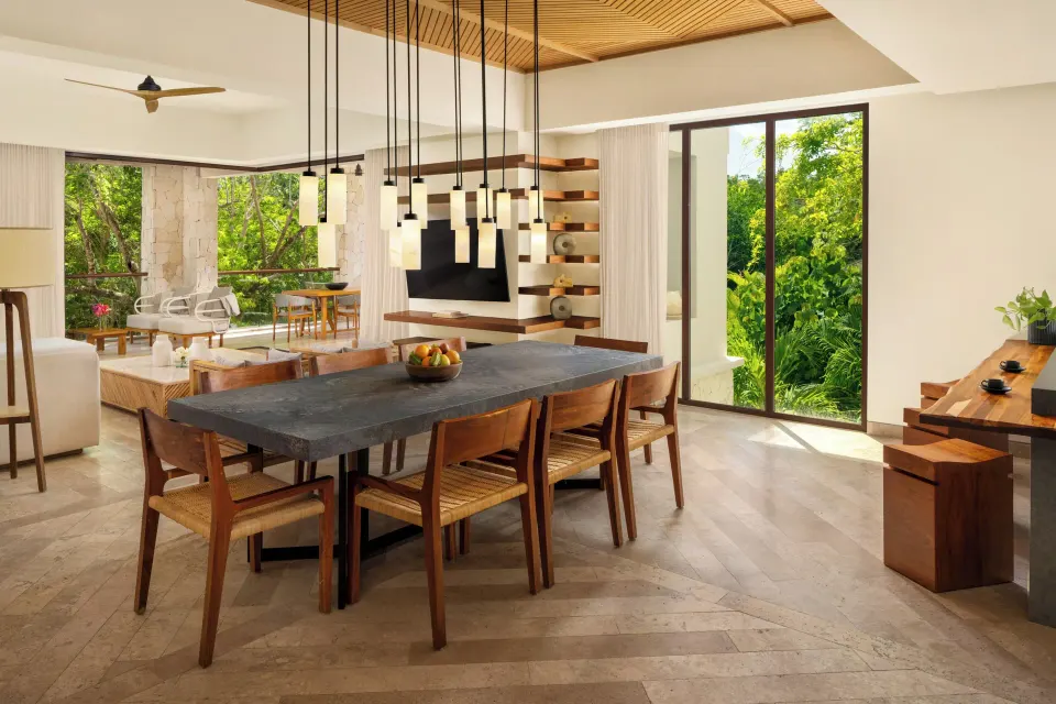 Villa living and dining area with forest-facing windows at Fairmont Heritage Place Mayakoba.
