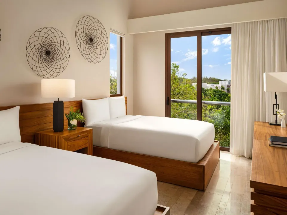 Double-bed villa bedroom with balcony doors at Fairmont Heritage Place Mayakoba.