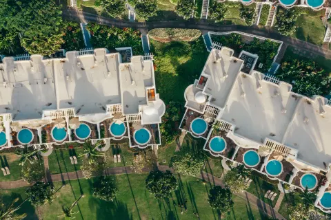 Aerial view of resort rooftops, lawns, paths, and plunge pools at Fairmont Kea Lani Maui.