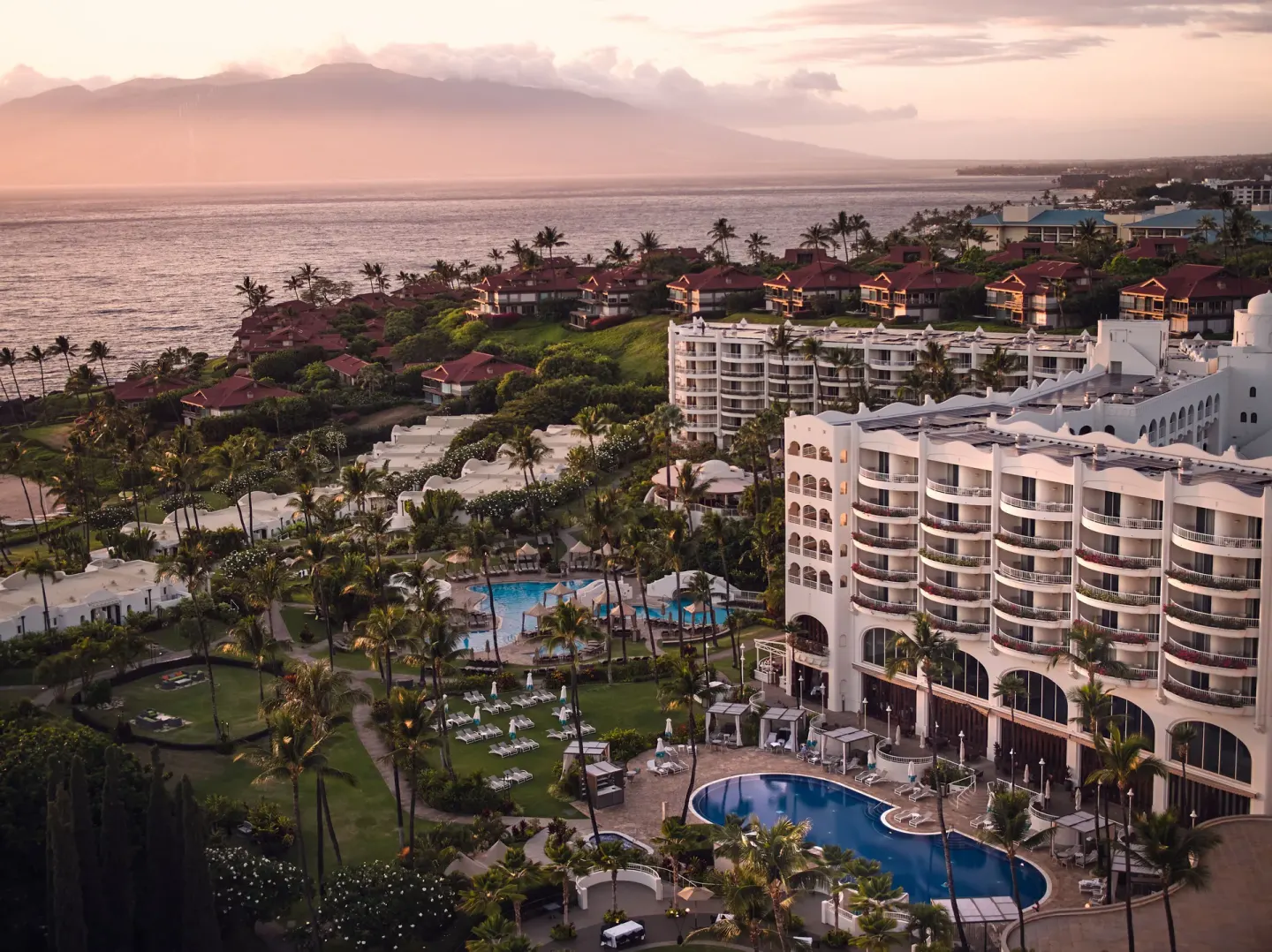 Aerial sunset view of pools, gardens, and oceanfront buildings at Fairmont Kea Lani Maui.