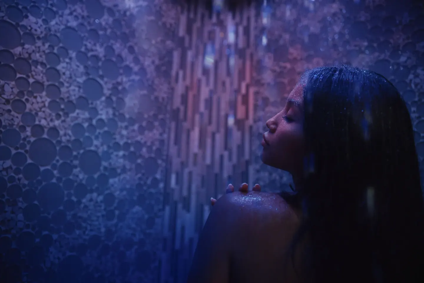 Guest in a blue-lit spa shower at Fairmont Kea Lani Maui.