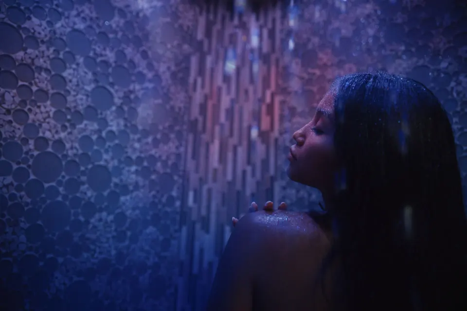 Guest in a blue-lit spa shower at Fairmont Kea Lani Maui.