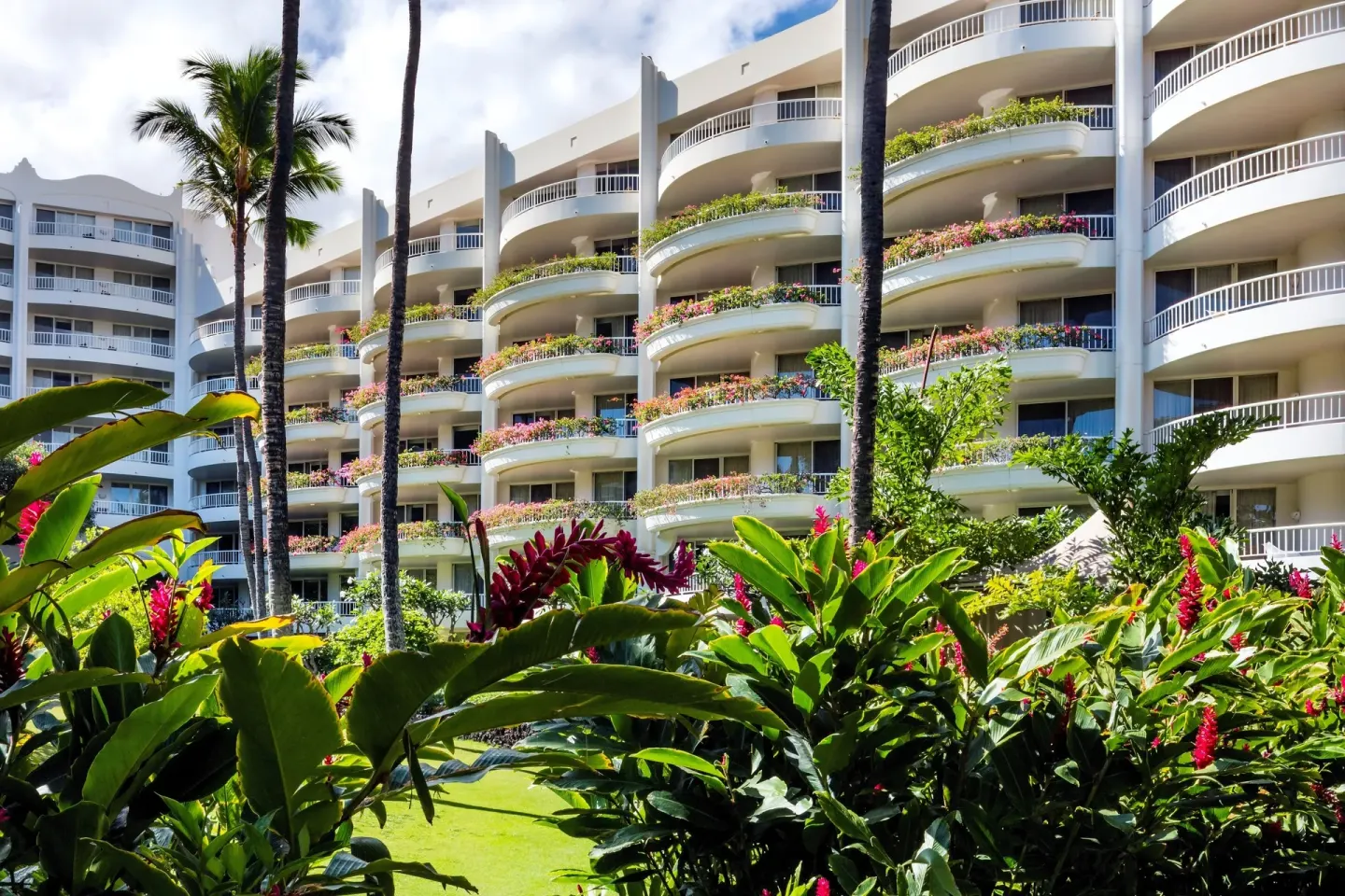 Curved guest room balconies above tropical gardens at Fairmont Kea Lani Maui.